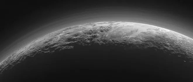 Near-sunset view of Pluto's icy mountains, plains and haze layers, by NASA's New Horizons